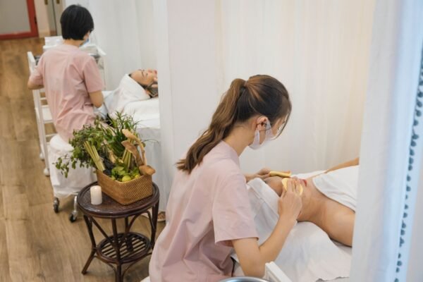 Two professionals provide soothing massage therapy in a calming spa environment.