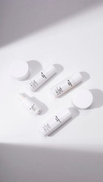 Overhead view of minimalistic skincare products on a white background, creating a clean aesthetic.