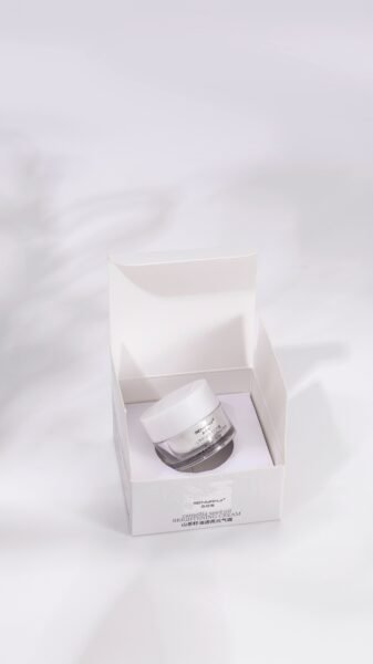 High-end skincare cream in an open white box with clean aesthetics and a focus on purity.