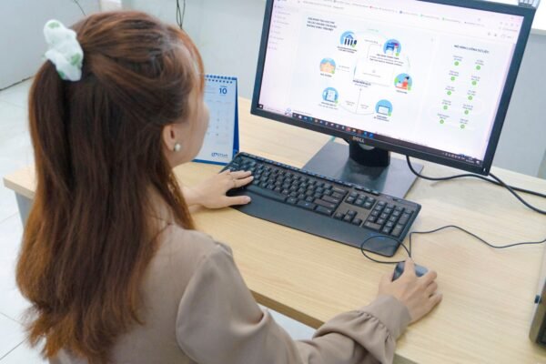 Young woman using desktop computer in office setting in Hanoi, Vietnam.