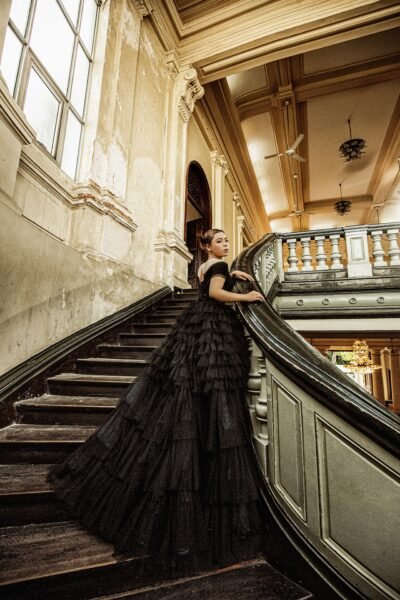 Stunning bridal portrait featuring a woman in a black gown on a classic staircase.