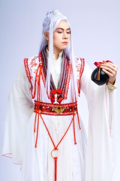 A person in traditional Asian attire with intricate red embroidery, showcasing cultural heritage.