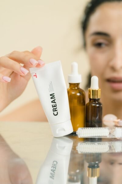 A woman selects skincare products including cream and serums, reflecting self-care.